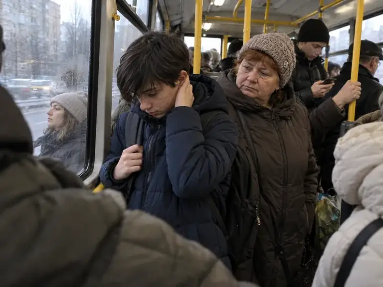 Дитина в міському транспорті закриває вуха через сенсорне перевантаження