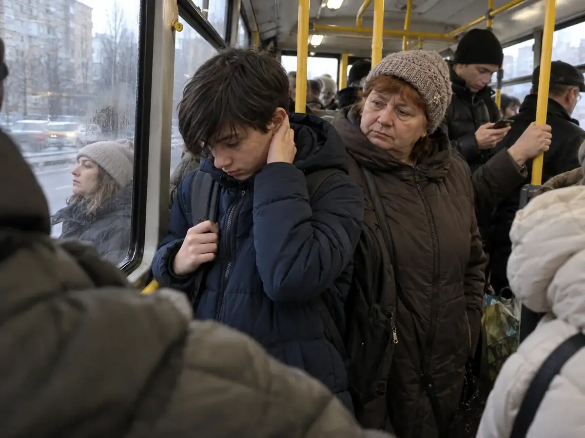 Дитина в міському транспорті закриває вуха через сенсорне перевантаження